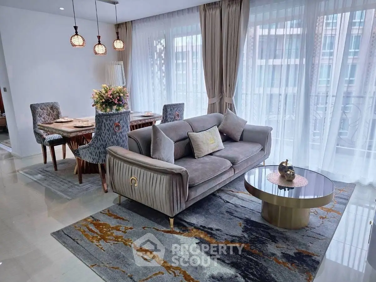 Elegant living room with plush sofa, stylish dining area, and floor-to-ceiling windows.