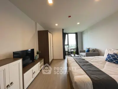 Spacious modern bedroom with stylish decor and large window view.
