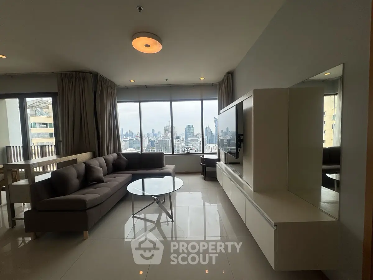 Spacious living room with city view, modern furniture, and large windows.