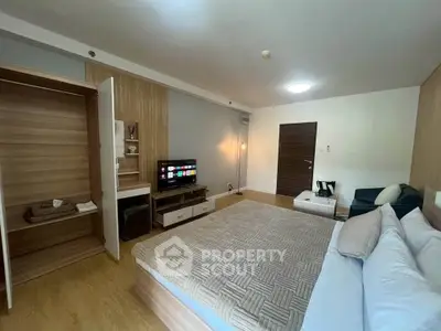 Spacious modern bedroom with wooden flooring and built-in wardrobe
