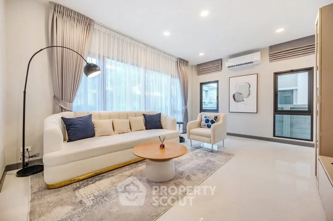 Spacious modern living room with elegant decor and large windows.
