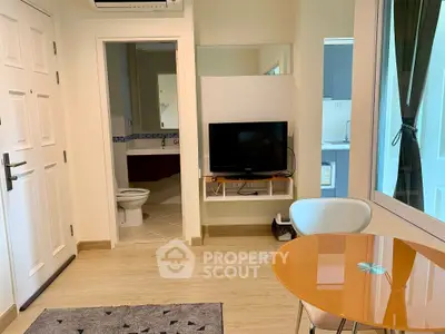 Modern studio apartment with cozy living area and bathroom view