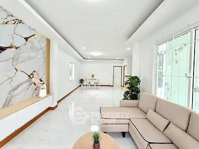 Spacious modern living room with elegant marble accents and cozy seating area.