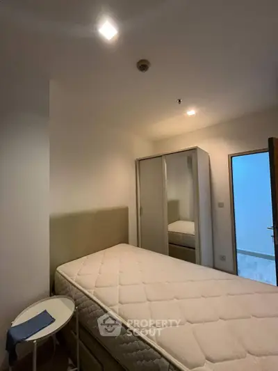 Cozy bedroom with modern design featuring a comfortable bed and mirrored wardrobe, perfect for relaxation.