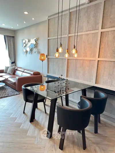 Modern living room with stylish dining area and elegant lighting fixtures.