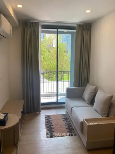 Cozy living room with balcony view, modern sofa, and natural light.