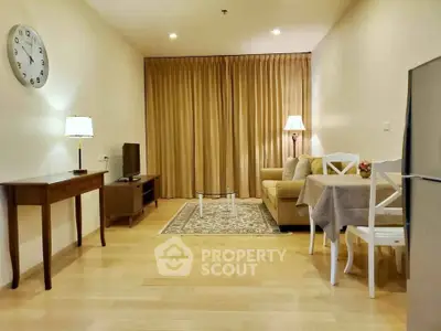 Cozy living room with elegant decor, featuring a comfortable sofa, stylish lamps, and a modern TV setup.
