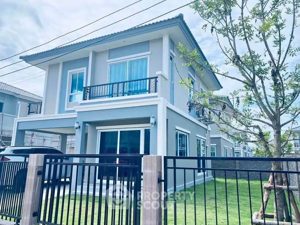 Modern two-story house with spacious lawn and sleek design in a serene neighborhood.