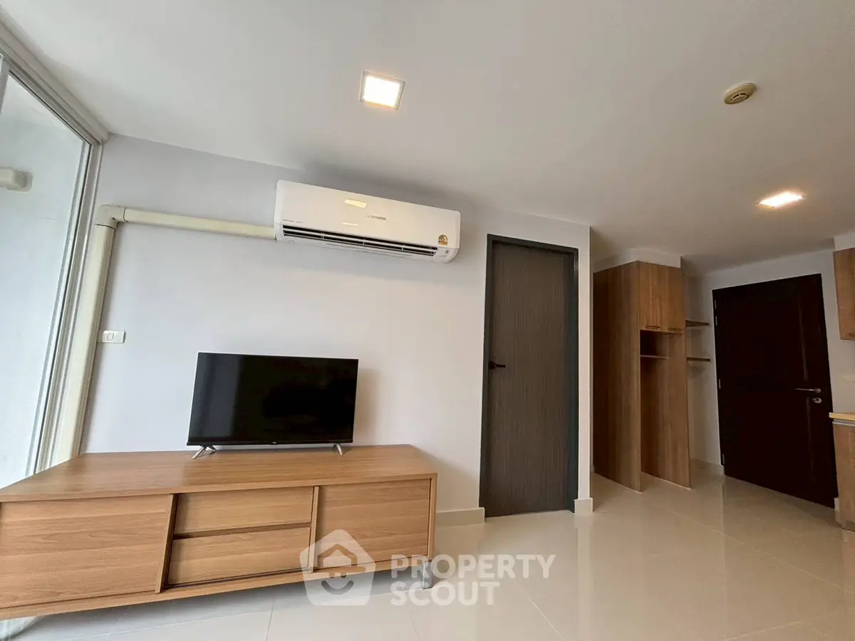 Modern living room with sleek wooden furniture and air conditioning, perfect for comfortable living.