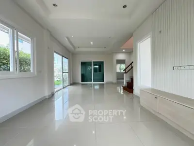 Spacious modern living room with large windows and sleek tile flooring