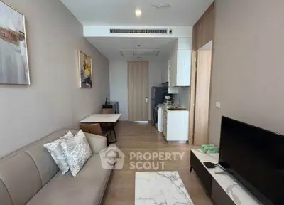 Modern living room with stylish decor and compact kitchen area in a cozy apartment.