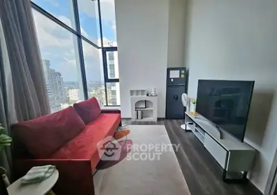 Modern living room with city view, featuring a red sofa and large TV, perfect for urban living.