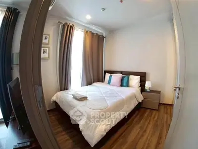 Cozy bedroom with wooden flooring and modern decor in a stylish apartment.