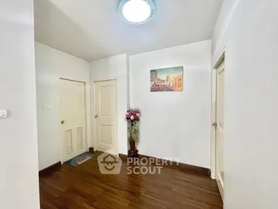 Bright hallway with wooden flooring and decorative wall art