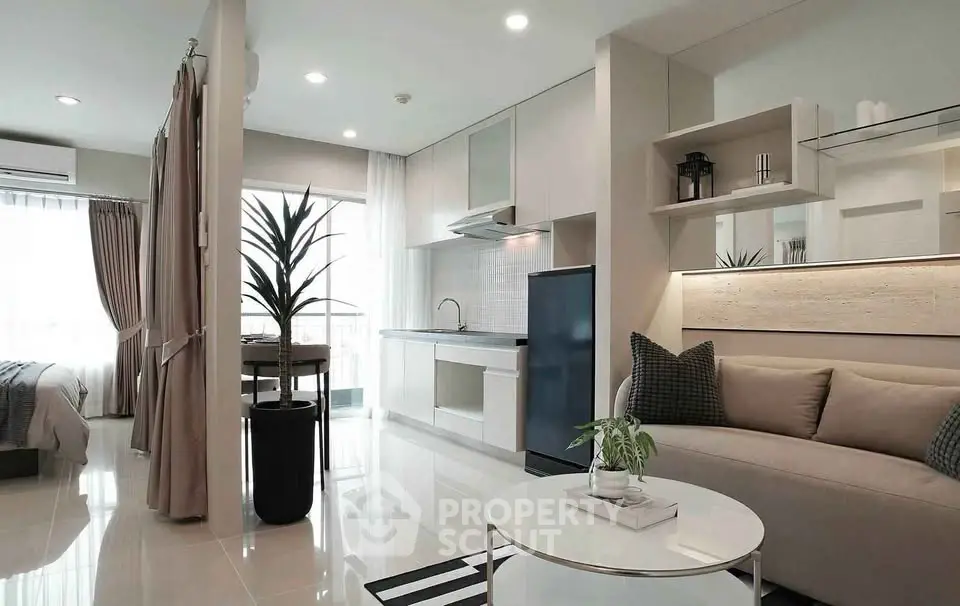 Modern open-plan living room and kitchen with elegant decor and natural light.