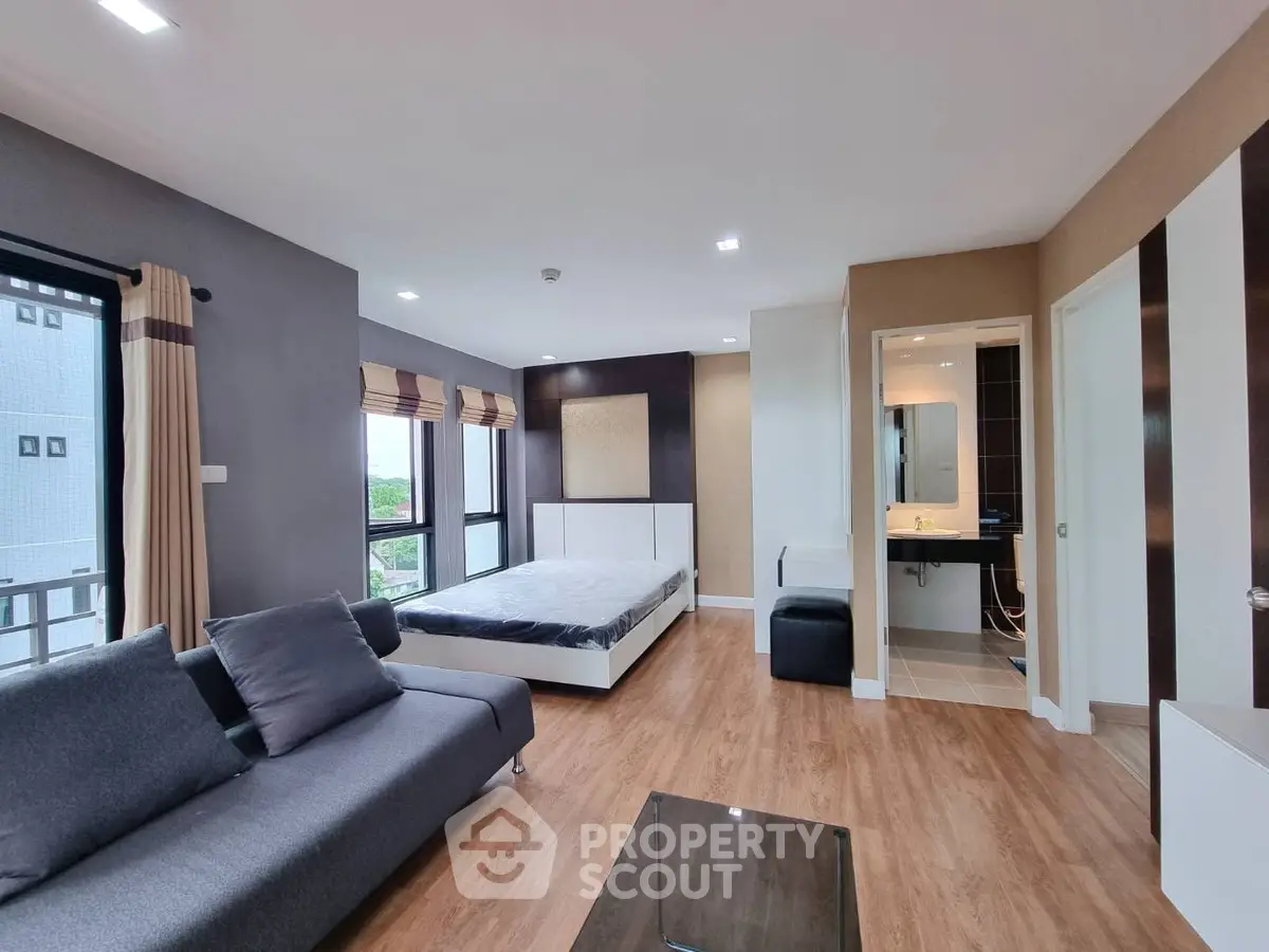 Modern studio apartment with stylish decor and large windows for natural light.