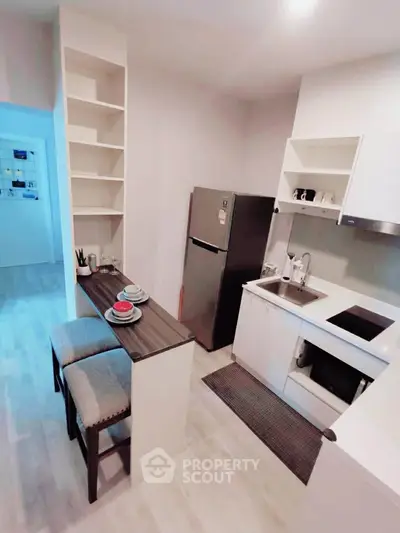 Modern compact kitchen with sleek design and breakfast bar in a cozy apartment.