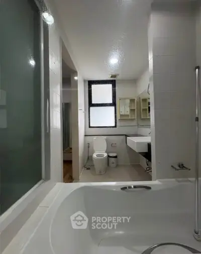 Modern bathroom with sleek fixtures and large bathtub in a contemporary apartment.