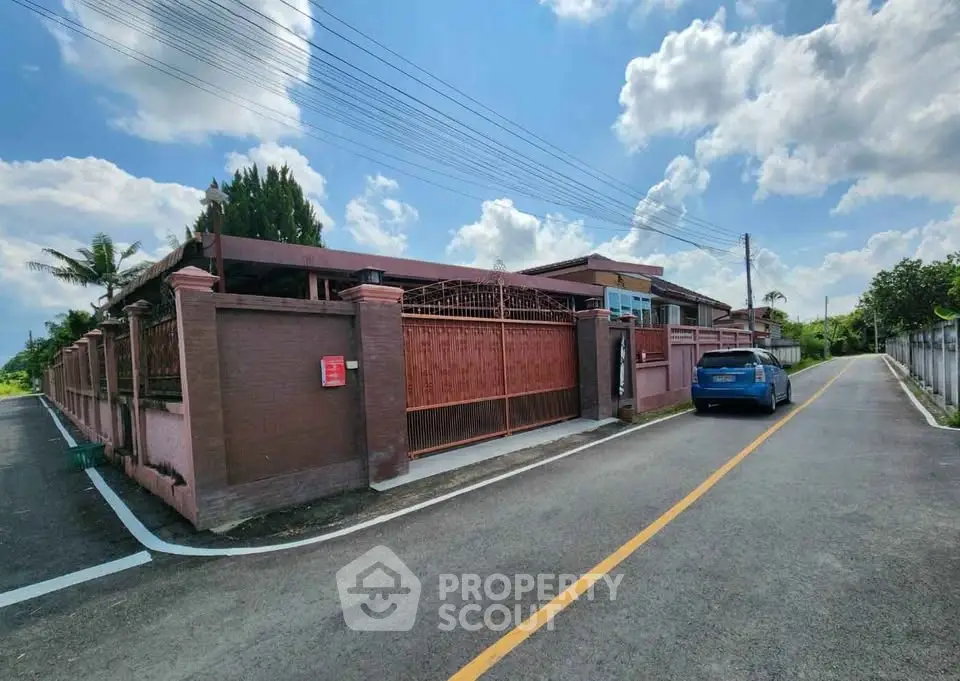 Charming single-story home with gated entrance and spacious driveway under a clear blue sky.