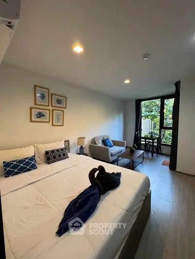 Cozy bedroom with modern decor and garden view, featuring a comfortable bed and stylish seating area.