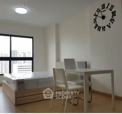 Modern bedroom with minimalist decor and large window view in urban apartment.
