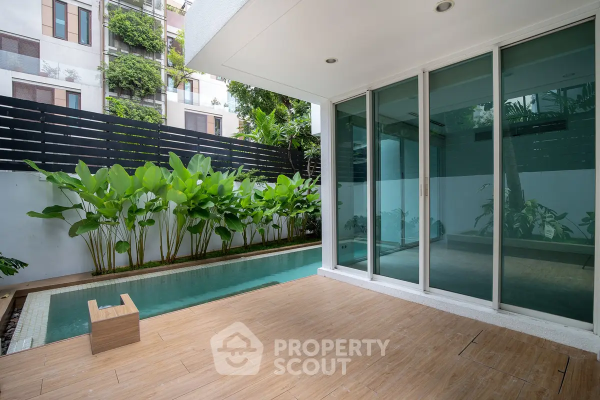 Modern patio with pool and lush greenery in a luxury apartment complex