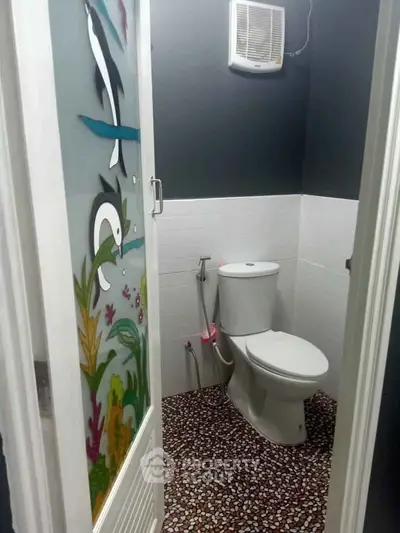 Charming bathroom with unique aquatic-themed door and modern fixtures.