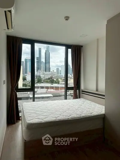Modern bedroom with city view, featuring large windows and natural light.