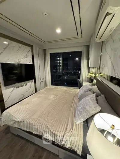 Luxurious bedroom with modern decor and city view, featuring elegant marble accents and ambient lighting.