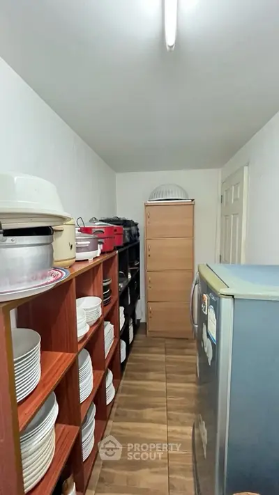 Compact storage room with shelves and appliances, ideal for organized living.