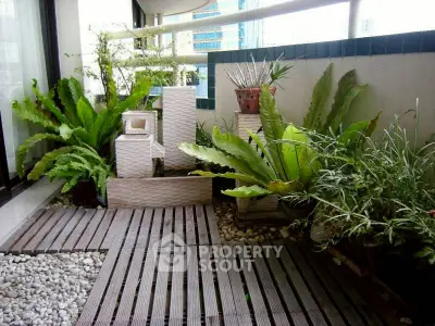 Charming balcony with lush greenery and modern wooden decking in urban setting.