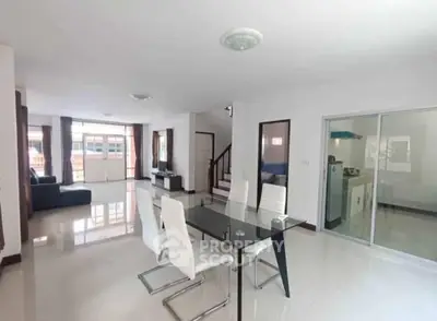 Spacious modern living room with dining area and sleek glass table, perfect for entertaining.