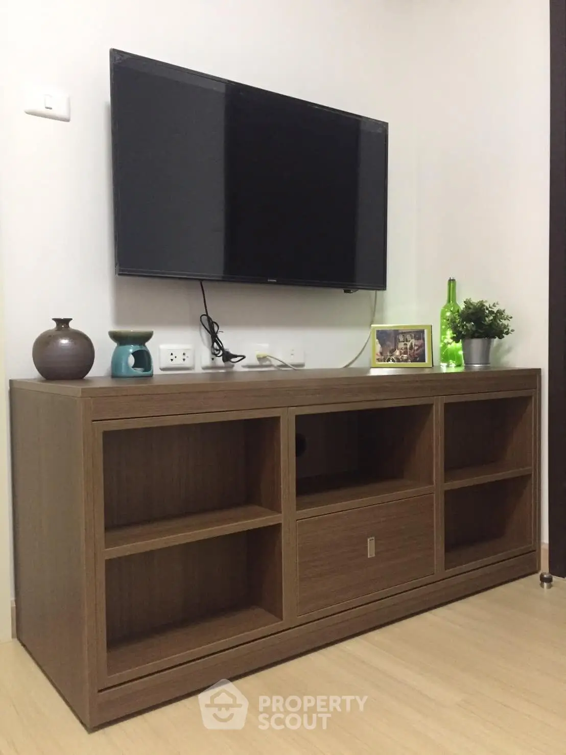 Modern living room with sleek wooden TV stand and mounted flat-screen TV, perfect for stylish home entertainment.