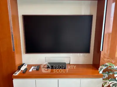 Modern living room with sleek TV setup and wooden cabinetry