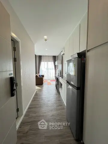 Modern apartment interior with open kitchen and living area, featuring sleek design and natural light.