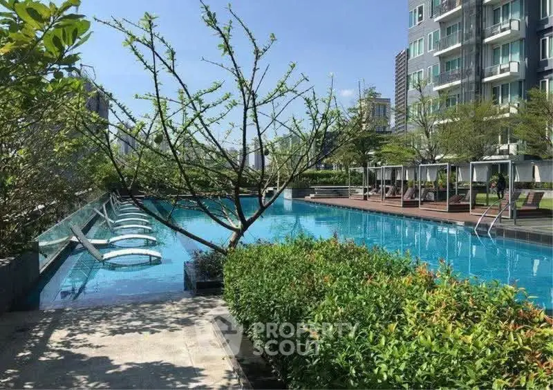 Luxurious apartment complex with stunning outdoor pool and lush greenery, perfect for relaxation and leisure.