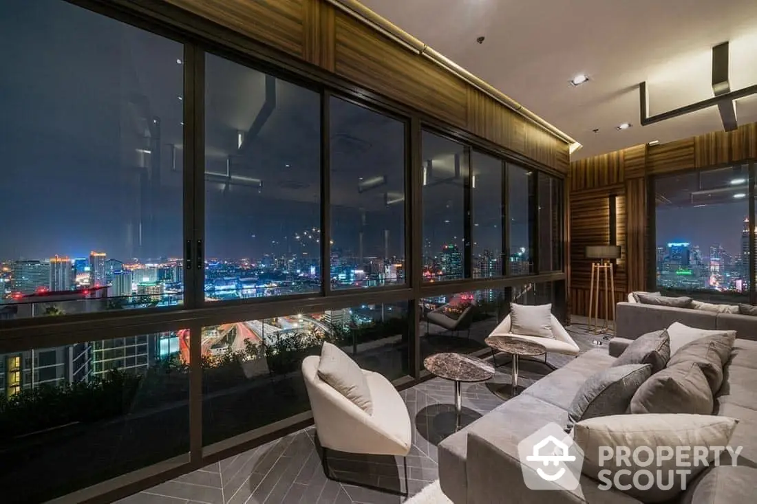 Luxurious high-rise living room with floor-to-ceiling windows offering a panoramic city skyline view, modern furnishings, and warm ambient lighting.