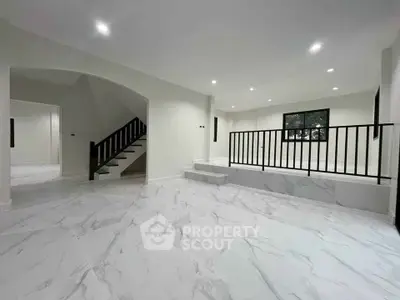 Spacious modern living room with marble flooring and elegant staircase