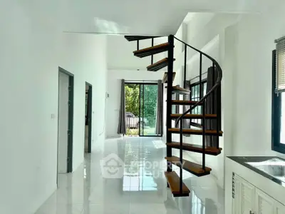 Modern interior with spiral staircase and large windows offering natural light and garden view.