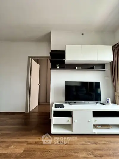 Modern living room with sleek TV unit and wooden flooring, perfect for cozy entertainment.