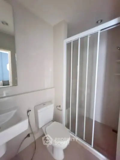 Modern bathroom with sleek shower enclosure and contemporary fixtures.