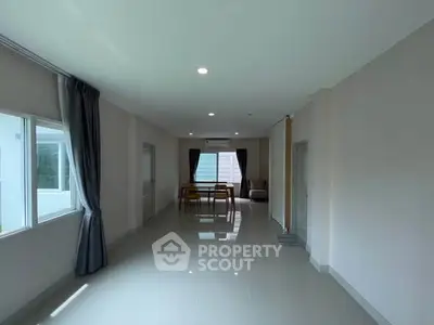 Spacious living room with large windows and modern dining area
