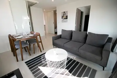 Modern living room with stylish furniture and dining area in open layout apartment.