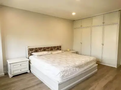 Spacious bedroom with elegant white furniture and ample storage space