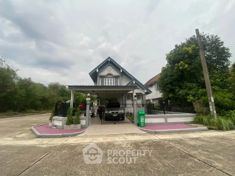 Charming suburban house with carport and lush greenery in a peaceful neighborhood.