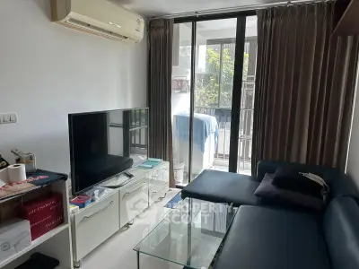 Cozy living room with modern furniture and large window leading to a balcony.