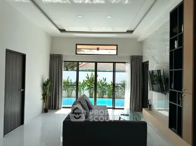 Luxurious living room with pool view, modern decor, and natural light.