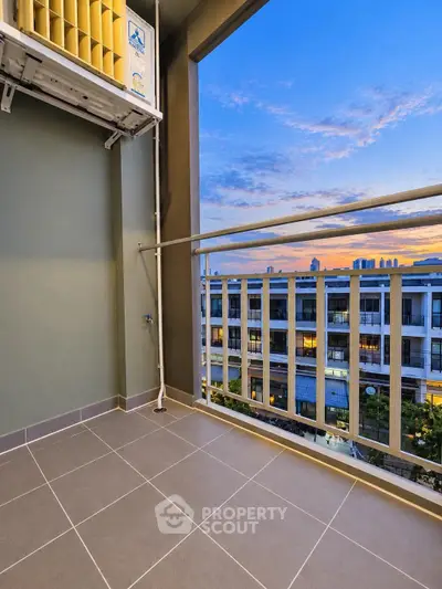 Modern balcony with stunning sunset view in urban apartment complex.