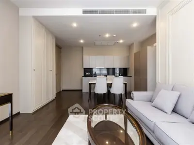 Modern living room with open kitchen, elegant furniture, and sleek design.