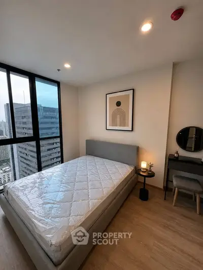 Modern bedroom with city view, featuring a stylish bed and minimalist decor in a high-rise apartment.